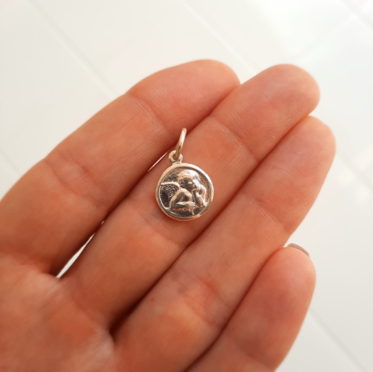 Dije redondo del ángel de la guarda, en plata 925. Mide 1 centímetro