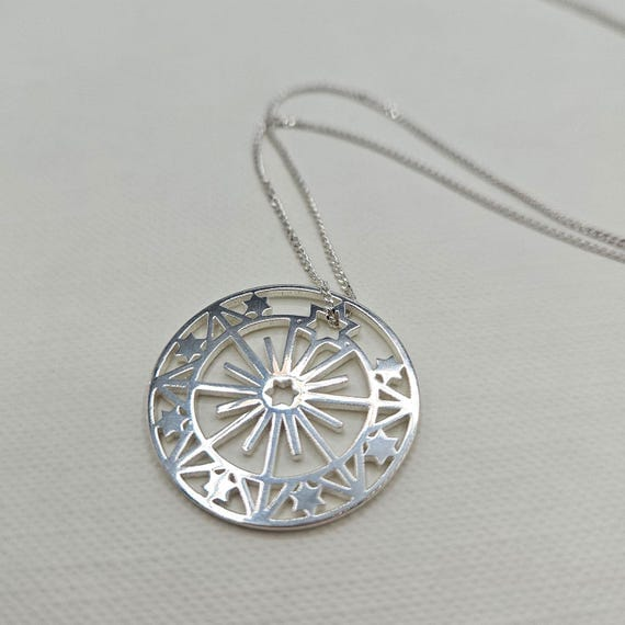 Dije Maru - Acero Blanco. Es un dije redondo con diseño de unas estrellas y líneas